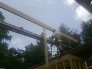 Carpenter setting a ridge beam over a new addition frame — Ice Dam Removal by Roofing Brothers in Stanleytown