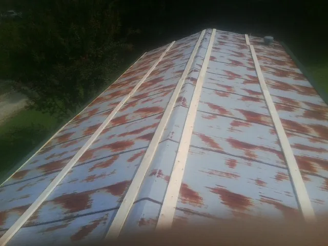 Rusted metal roof panels with new wood purlins before replacement — Storm Damage Roof Repair in Stanleytown by Roofing Brothers