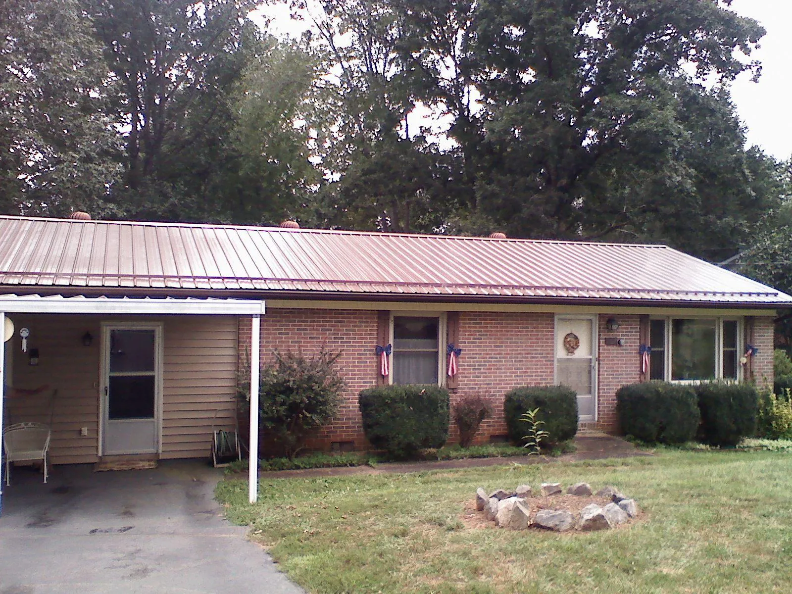 Bronze metal roof and carport on a brick ranch home — Roof Repair work by our crew in Stanleytown